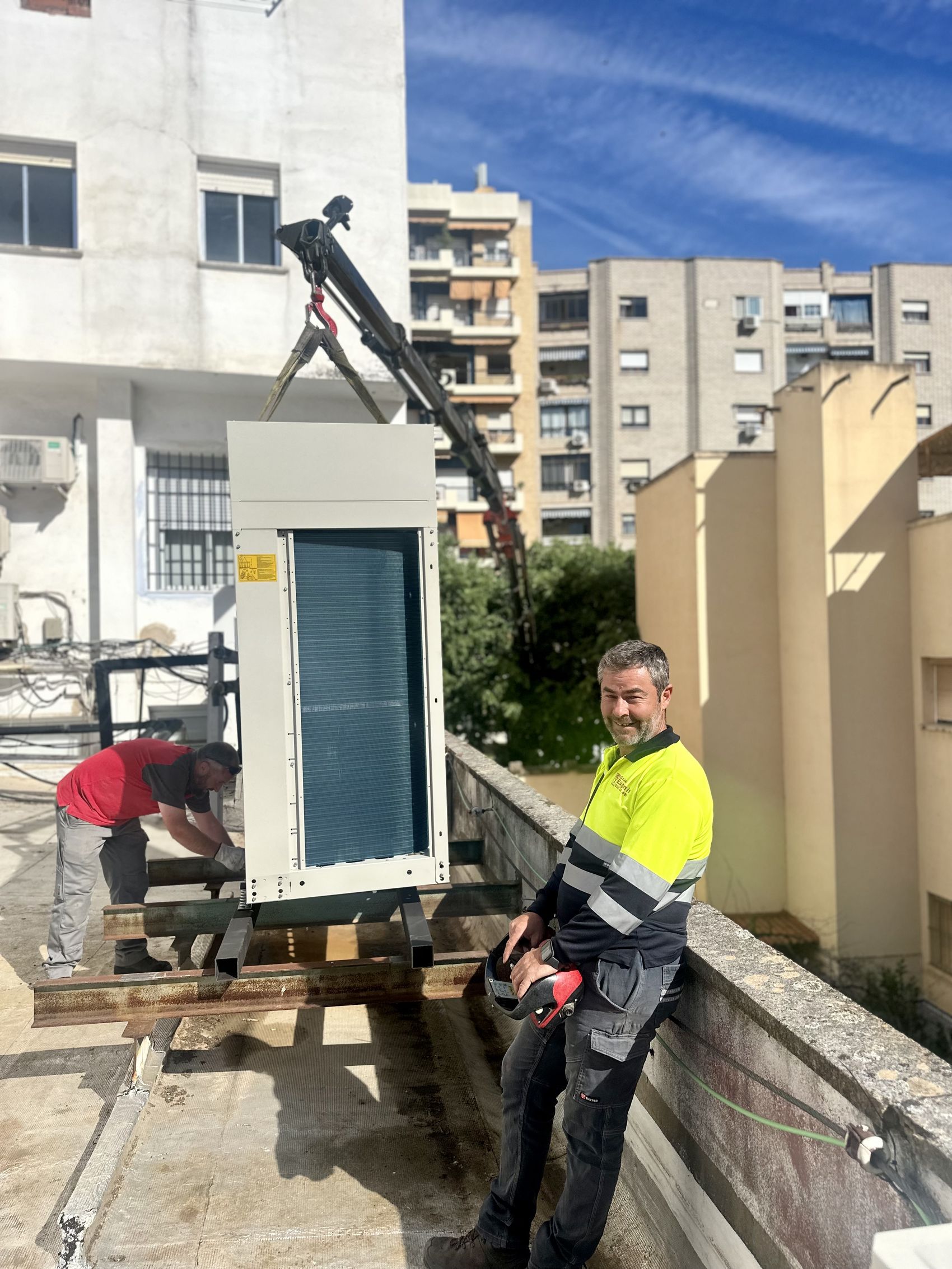 Operarios montando un climatizador en una cubierta