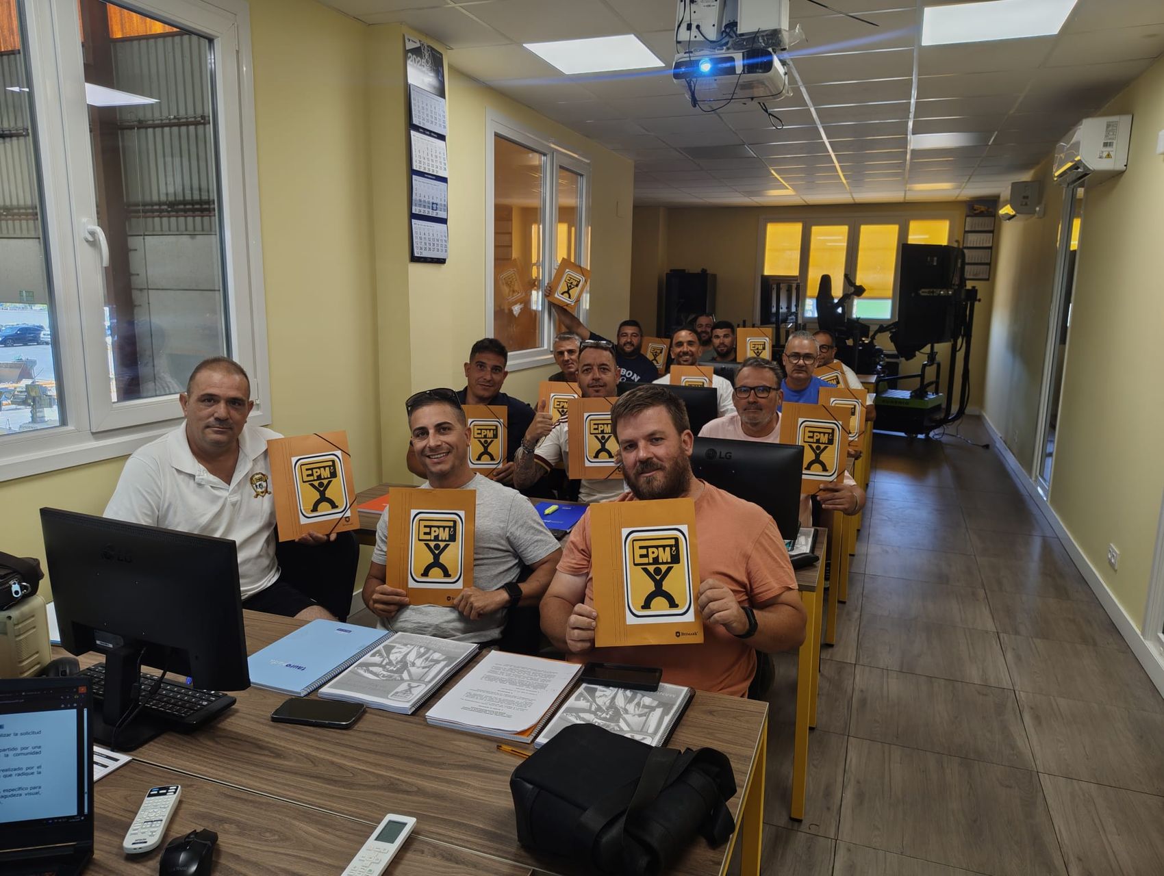 Alumnos en el aula con las carpetas del curso de operador de grúa
